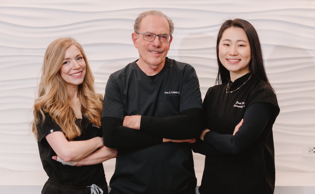 Two female and one male doctor with arms crossed